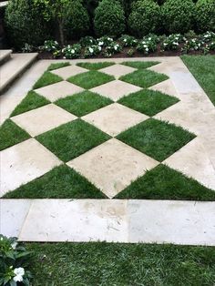 a checkerboard pattern made out of grass in the middle of a yard with steps leading up to it