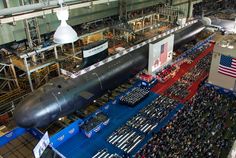 an overhead view of a large crowd in a building with a submarine on the floor