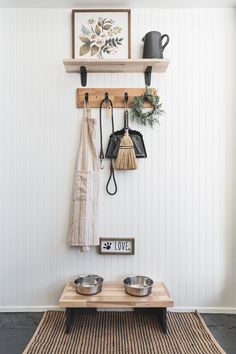 a dog bowl and two bowls on a wooden table in front of a white wall