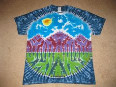 a tie - dyed shirt with mountains and trees on it