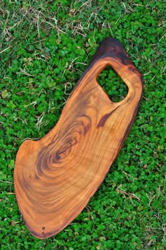 a wooden cutting board laying in the grass