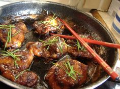 meat and vegetables cooking in a pan with chopsticks