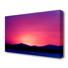 the sun is setting over mountains in this purple and blue sky canvas wall art print