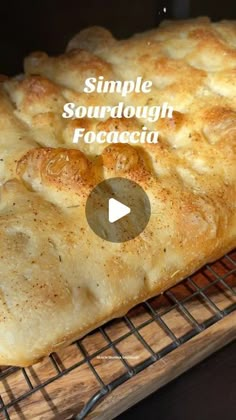 a large piece of bread sitting on top of a cooling rack with the words simple sourdough foccacia