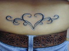 a woman with a heart tattoo on her lower back and the word love is written in cursive writing