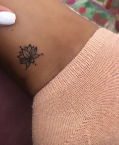 a woman's foot with a small lotus tattoo on the left side of her ankle