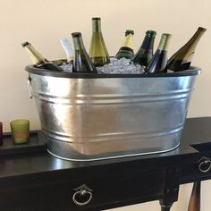 a metal bucket filled with wine bottles on top of a table