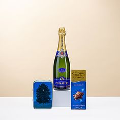 a bottle of wine and chocolates on a white table with a blue tint