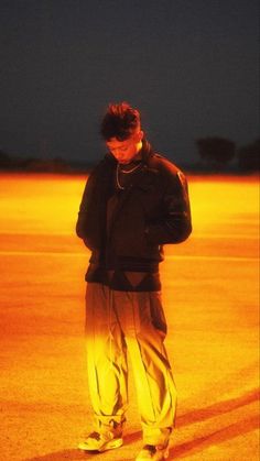 a man standing in the middle of an empty parking lot with his hands on his hips