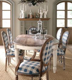 a dining room table with blue and white checkered upholstered chairs around it