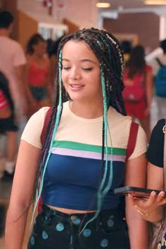 two girls with braids are looking at their cell phones