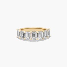 a gold ring with three emerald cut diamonds