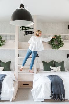 a woman standing on top of a bunk bed