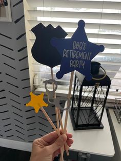 a person holding up two wooden picks with the words do's and don'ts retirement party written on them