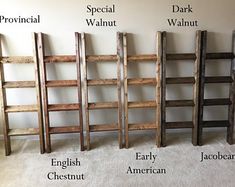 four wooden ladders labeled in different languages and sizes, standing against a white wall