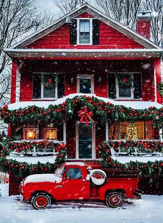 a red truck parked in front of a house covered in christmas decorations