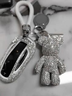 a keychain with a teddy bear on it and a cell phone attached to it