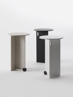 three round tables with wheels on each side and one in black, white and grey