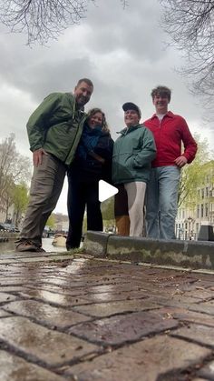 four people posing for a photo in the rain