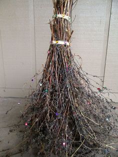 a pile of twigs sitting on top of a sidewalk next to a white wall and door