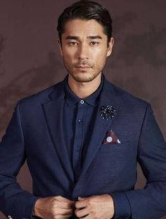 a man in a blue suit with a flower on his lapel