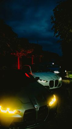 two cars parked next to each other at night