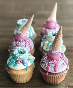 three cupcakes with colorful frosting and sprinkles are on a table