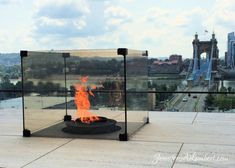 a fire pit on top of a building with a view of the city in the background