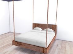 a bed that is made out of wood and has white sheets on top of it