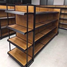 an empty shelf in a store filled with lots of wooden shelves and shelving units