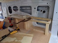 the inside of a van is being built with wood and tools on it's side