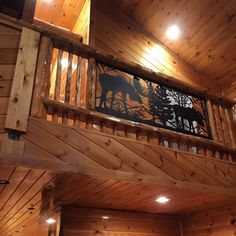 the inside of a cabin with wood paneling and metal artwork on the railings