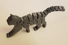 an animal made out of legos on a white surface with no one around it