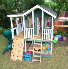 a child's play house in the backyard with slide and sandboxes on the ground