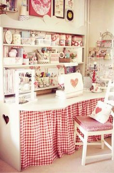 a room filled with lots of white furniture and red checkered table cloth on top of it