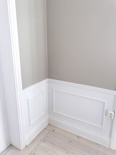 the corner of a room with white walls and wood flooring, painted in light gray