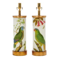 two green parrots sitting on top of a wooden stand next to each other,