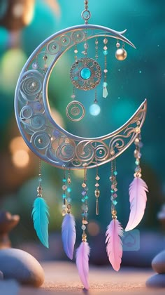 a crescent moon with feathers hanging from it's sides and beads on the side