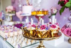 a table topped with lots of cakes and cupcakes