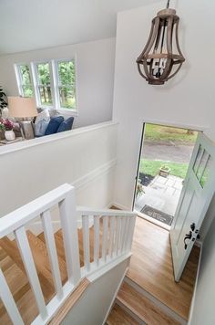 an open door leading to a living room with wood flooring and white painted walls