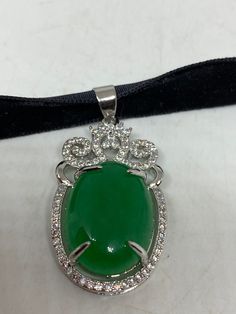 Vintage Green Jade Choker Silver Finish necklace pendant All green Jade set in an ornate silver set with small crystals White bronze frame. Over 2 in long Hung on a black velvet ribbon Can hang on a chain All jewelry is shipped free in the US in a nice gift box. Check out our over a THOUSAND great reviews Formal Green Locket Necklace, Green Pendant Jewelry For Evening, Formal Green Locket Jewelry, Jade Choker, Crystals White, Black Velvet Ribbon, Choker Silver, Small Crystals, Bronze Frame