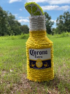 a bottle that is sitting in the grass with a string wrapped around it's neck