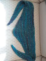 the back of a couch with blue beads on it's arm and one end