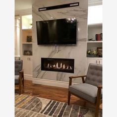 a living room with a tv mounted on the wall and a chair in front of it