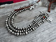 A True Treasure! Adjustable with Leather & a Slider Bead ~ 3 Strand Navajo Handmade NecklaceYou won't find a better price for a treasure like this anywhere in the world!Looks great worn short as a collar style or extra long.Adjustable from 14 to 36 inches with the leather and silver slider bead.The Silver Pearls are 4, 6 and 8 Designs by Jona Bonecutter ~ Handmade by Navajo Artists ~ Marlene Gorman ~ Alaina Beautiful Bald Eagle ~ Kayla John ~ Brendan Allen Free shipping in the USA!Every necklace Traditional Handmade Jewelry For Everyday Use, Handmade Jewelry With Round Beads For Daily Use, Handmade Round Beads Jewelry For Everyday Use, Artisan Jewelry With Round Beads For Everyday Use, Rustic Silver Beaded Jewelry, Rustic Silver Jewelry With Round Beads, Silver Beaded Jewelry For Everyday, Rustic Jewelry With Polished Round Beads, Casual Bohemian Silver Jewelry