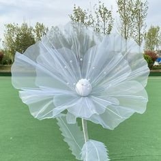 a large white flower on top of a green field