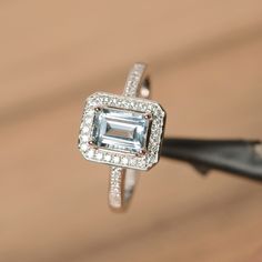 It is real natural aquamarine ring, the emerald cut aquamarine is about 5mm*7mm, weight about 0.86 carats. The basic metal is sterling silver and plated with rhodium. To change the metal to a solid gold (white/rose) or platinum is also available, please ask for a quotation if you want. You can also go to my shop Home for more elegant rings: https://www.etsy.com/shop/godjewelry?ref=hdr_shop_menu Aquamarine is the birthstone of January. More aquamarine rings: https://www.etsy.com/shop/godjewelry?r Elegant Rings, Oval Halo Engagement Ring, Pink Morganite Engagement Ring, Green Amethyst Ring, Sterling Silver Promise Rings, Wedding Rings Halo, London Blue Topaz Ring, Ring Emerald, Aquamarine Ring