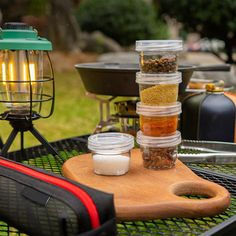 there are many containers on the table with spices and seasonings in them for cooking