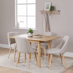 a dining table with four chairs and a potted plant