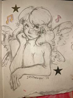 a drawing of an angel sitting on top of a piece of paper